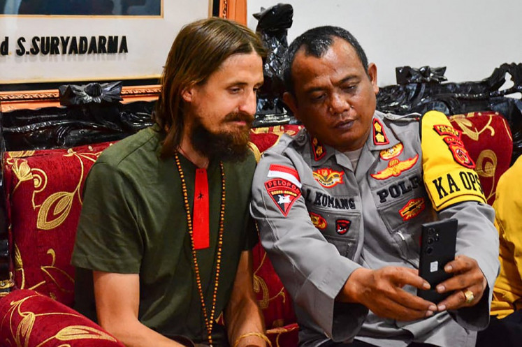 New Zealand pilot Phillip Mehrtens (left) poses for a selfie with a police officer on Sept. 21, 2024 at a press conference in Timika, Papua, following his release by a faction of the West Papua National Liberation Army (TPNPB) that had held him captive for 19 months.