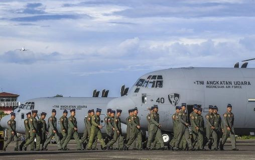 New wings: Indonesian Air Force officers walk on Jan. 24, 2024 past Lockheed Martin C-130J-30 Super Hercules at Halim Perdanakusuma Air Base in East Jakarta. The transport planes were among the new aircraft procured by Defense Minister Prabowo Subianto.