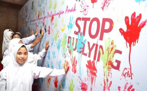 Hands up: Students make handprints on Nov. 12, 2018, to create a mural as part of an anti-bullying campaign in Medan, North Sumatra.

