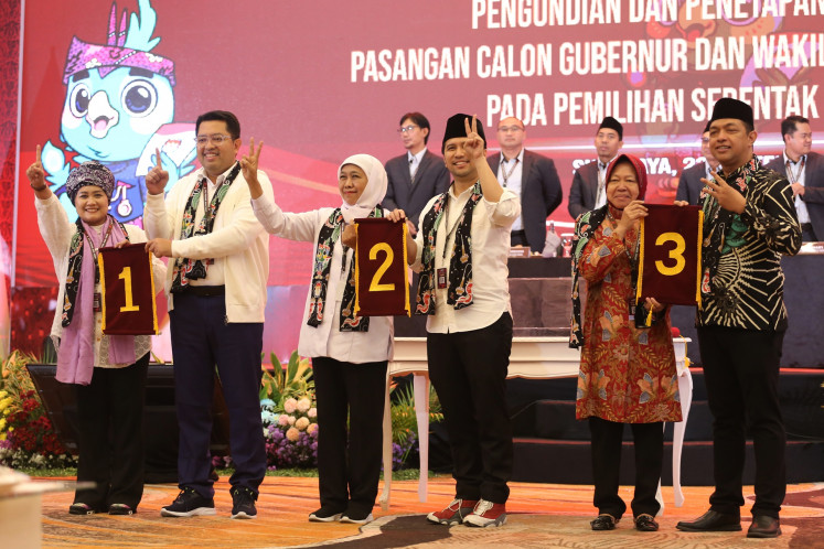 East Java gubernatorial candidate pairs Luluk Nur Hamidah and running mate Lukmanul Hakim (left); Khofifah Indar Parawansa and running mate Emil Dardak (center); and Tri Rismaharini and running mate Zahrul Azhar Asumta show their ballot numbers on Sept. 23, 2024, at the General Elections Commission (KPU) East Java office in Surabaya.