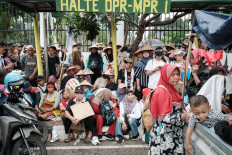 Farmers and their families shelter from the rain on Sept. 24, 2024, during a protest against what they described as the government's failure to implement agrarian reform as they commemorate the Indonesian National Farmers' Day in front of the parliament building in Jakarta.
