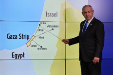 Israel's Prime Minister Benjamin Netanyahu points at Tel Aviv on a map during a press conference at the Government Press Office (GPO) in Jerusalem on September 4, 2024. 