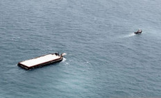 A tugboat tows a barge carrying sea sand bound for Singapore in the waters of Riau Islands province on Feb. 10, 2015.
