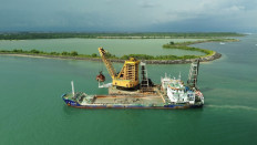 A crane on a floating platform extract sand from the sea in Benoa Bay, Bali on Jan. 29, 2024.