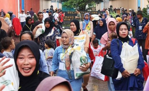 A crowd of residents heads out of a government distribution point in Sukadanau village, Bekasi, West Java, after receiving free rice via a social welfare program on Feb. 16, 2024.