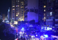 People gather outside an apartment building hit by an Israeli air strike in Beirut's Cola district, September 30, 2024. Two people were killed in an Israeli strike on Beirut on September 30, a Lebanese security source said, the first strike on the city itself since the October 7 Hamas attack on Israel last year. An Israeli drone targeted an apartment belonging to two members of the Lebanese Islamist group Jamaa Islamiya, said the source. 
