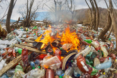 A pile of garbage, including plastics, burns in this undated stock image.