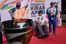 National Paralympic Games (Peparnas) committee chief D.B. Susanto (left) lights the 17th Peparnas cauldron at the Surakarta City Hall during a parade to promote the sporting competition on Sept. 29, 2024. This year’s Peparnas, slated for Oct. 6 to 13, will see more than 4,500 athletes from 34 provinces competing in 20 sports.