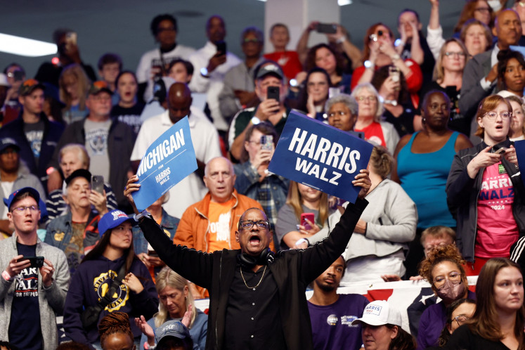 Seorang pendukung memegang plakat saat acara kampanye calon presiden dari Partai Demokrat dan Wakil Presiden Amerika Serikat Kamala Harris di Dort Financial Center di Flint, Michigan, AS, pada 4 Oktober 2024.