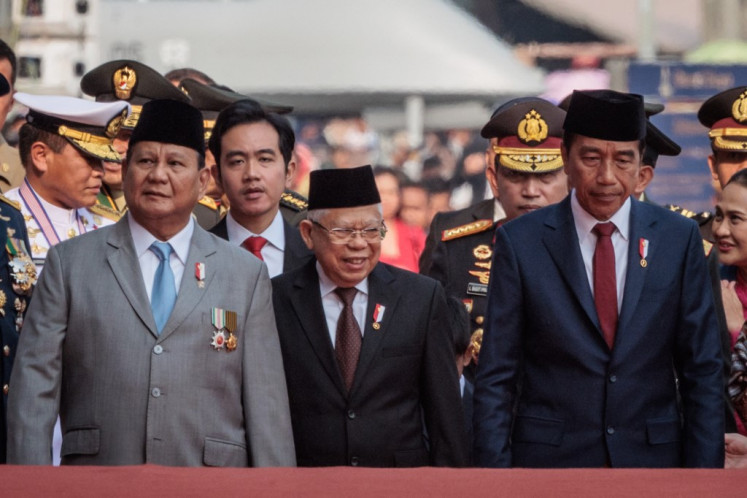 Presiden Joko “Jokowi” Widodo (kanan) dan Wakil Presiden Ma'ruf Amin (kedua kanan) berdiri di samping Menteri Pertahanan dan presiden terpilih Prabowo Subianto (kiri) dan wakil presiden terpilih Gibran Rakabuming Raka pada 5 Oktober 2024 pada acara ke-79 perayaan HUT Tentara Nasional Indonesia (TNI) di Monumen Nasional Lapangan Merdeka, Jakarta Pusat.