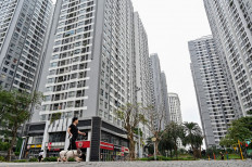 A woman walks her dog in a residential complex in Hanoi on Sept. 25, 2024.