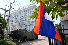 Soldiers sit next to an armoured vehicle outside a hotel during the ASEAN Summit in Vientiane on Oct. 8, 2024.