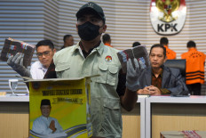 A Corruption Eradication Commission (KPK) investigator shows money seized in a series of arrests in South Kalimantan during a press briefing at the KPK headquarters in Jakarta on Oct. 8, 2024. The antigraft body arrested eight suspects in the operation, including provincial Public Works and Housing Agency official Yulianti Erlynah, and has named South Kalimantan Governor Sahbirin Noor a suspect in the case.