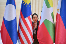 A police official looks on between national flags during the 44th and 45th ASEAN Summits in Vientiane on Oct. 9, 2024.