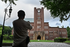 A man takes a photo of Yasuda Auditorium, built in 1925, at the University of Tokyo, also known as Todai, in Tokyo on Aug. 22, 2024. Just one in 10 researchers at the prestigious University of Tokyo are women, and one in five students.