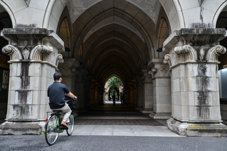 A man rides a bicycle on the campus of the University of Tokyo, also known as Todai, in Tokyo, on Aug. 22, 2024.