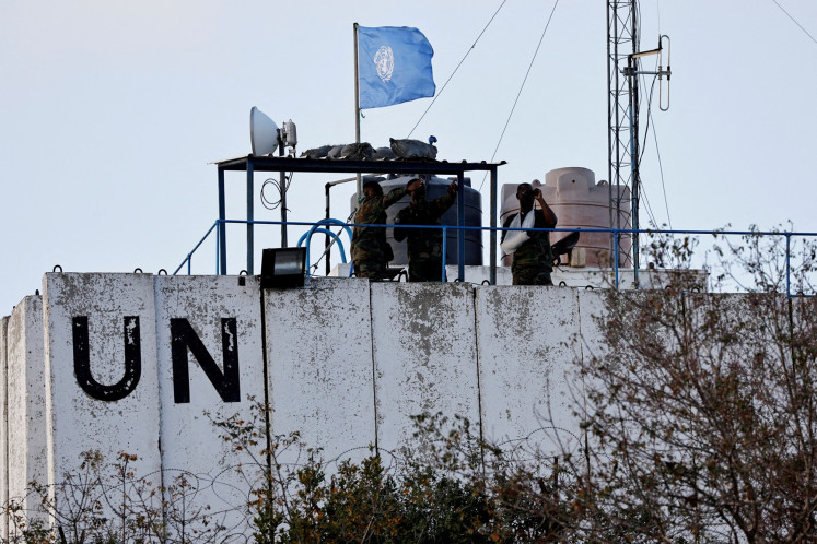 Members of the United Nations Interim Force in Lebanon (UNIFIL) look at the Lebanese-Israeli border as they stand on the roof of a watch tower &rlm;in the town of Marwahin in southern Lebanon on Oct. 12, 2023.