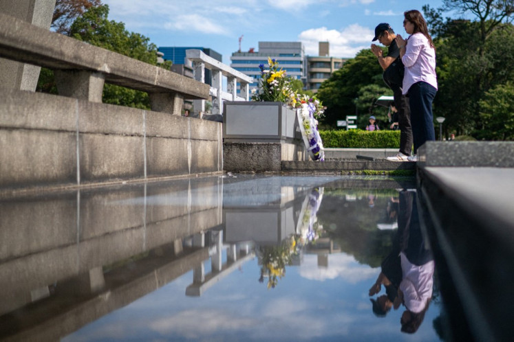 Orang-orang berdoa di depan cenotaph di Taman Peringatan Perdamaian Hiroshima di kota Hiroshima, Jepang pada 12 Oktober 2024.