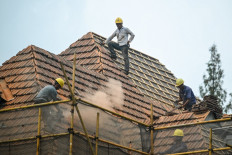 Workers repair a roof of a house in the district of Xuhui, in Shanghai on Sept. 10, 2024.