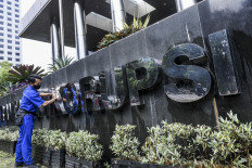 A worker cleans a Corruption Eradication Commission (KPK) sign on April 25, 2024, at the KPK headquarters in Jakarta. 
