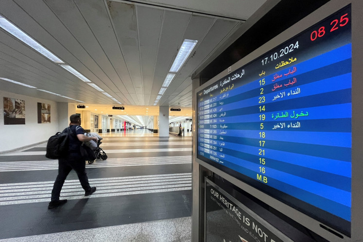 Seorang pria berjalan di samping papan informasi penerbangan di Bandara Internasional Beirut–Rafic Hariri di Beirut, Lebanon, pada 17 Oktober 2024.