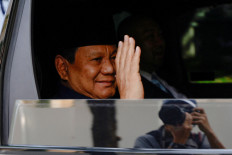 President-elect Prabowo Subianto waves to journalists as he leaves his residence on Jl. Kertanegara in South Jakarta for the Senayan legislative complex ahead of his presidential inauguration on Oct. 20, 2024 