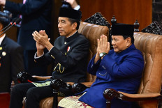 Former president Joko “Jokowi“ Widodo (left) and President Prabowo Subianto (right) greet attendants of the presidential inauguration ceremony on Oct. 20, 2024, at the Senayan legislative complex in Jakarta.