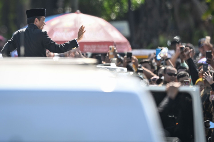 Former president Joko “Jokowi“ Widodo greets people on his way to the Halim Perdanakusuma Airport following the peaceful transfer of power to newly installed President Prabowo Subianto, on Oct. 20, 2024.