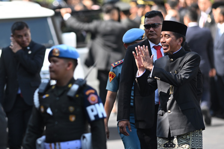 Former president Joko “Jokowi“ Widodo greets the crowd after a military ceremony to send him off at the Merdeka Palace in Jakarta on Oct. 20, 2024.