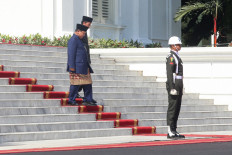 President Prabowo Subianto (left) and his predecessor Joko “Jokowi“ Widodo (second left) arrive to review the guard of honor during the presidential inauguration ceremony at the State Palace in Jakarta on Oct. 20, 2024.