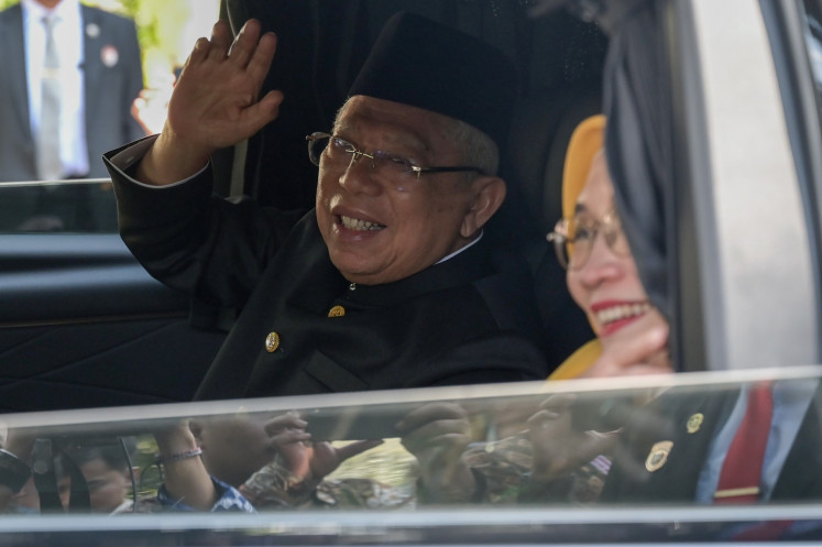 Former vice president Ma'ruf Amin waves to journalists on Oct. 20, 2024, accompanied by his wife Wury Estu Handayani, as he leaves the vice presidential palace compound on Jl. Medan Merdeka Selatan in Central Jakarta.