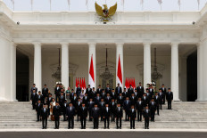 Indonesian President Prabowo Subianto, Vice President Gibran Rakabuming Raka and newly appointed cabinet ministers pose for photos on Oct. 21, 2024, after the inauguration of the new cabinet, at the Presidential Palace in Jakarta, Indonesia. 