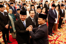 Budi Gunawan (left, front), a former chief of the State Intelligence Agency, shakes hands with President Prabowo Subianto during his inauguration as coordinating political and security minister on Oct. 21, 2024, at the State Palace in Central Jakarta.