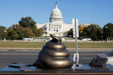 A new temporary statue of a brass-colored desk with a large poop-shaped emoji on top of it, referencing those who attacked the United States Capitol on Jan. 6, 2021, is seen near the Capitol in Washington on Oct. 25, 2024.