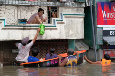 People on a boat conduct relief operations at a flooded area due to the heavy rains brought about by Tropical Storm Trami in Naga, Camarines Sur, the Philippines on Oct. 25, 2024. Philippine rescue workers battled floodwaters on Oct. 25 to reach residents still trapped on the roofs of their homes as Tropical Storm Trami moved out to sea after killing at least 40 people.