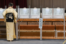 A woman in a traditional kimono votes during the general election at a polling station set up at a local school in Tokyo on October 27, 2024. 