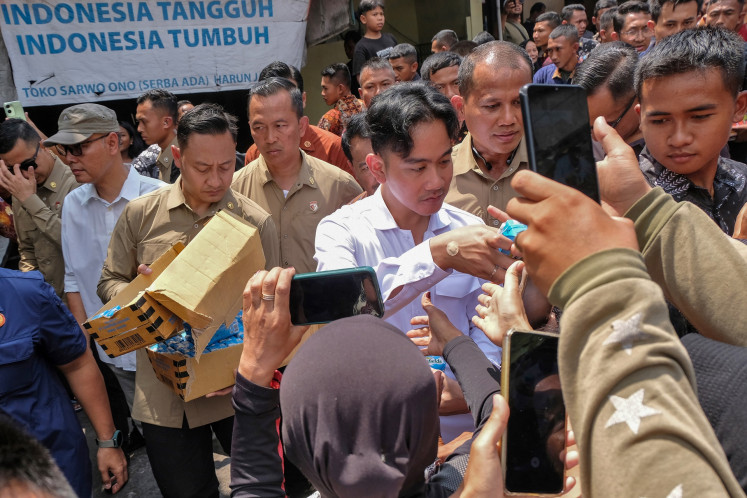 Check in: Wakil Presiden Gibran Rakabuming Raka (tengah) membagikan sekotak susu kepada penonton saat kunjungan mendadak ke Pasar Gotong Royong di Magelang, Jawa Tengah, pada 27 Oktober. Wakil Presiden mengunjungi pasar untuk memeriksa harga bahan pokok .