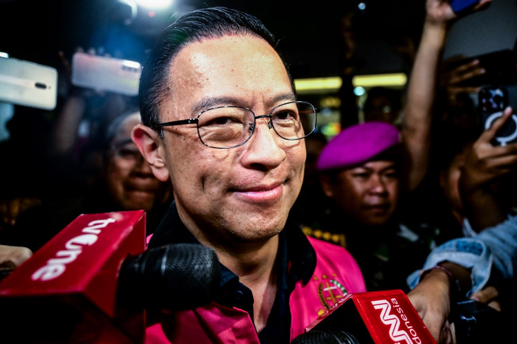 Former trade minister Thomas Lembong (center) wears a detainee jacket after the Attorney General's Office (AGO) named him a suspect in a corruption case on Oct. 29. Thomas, who campaigned on behalf of the Anies Baswedan-Muhaimin Iskandar ticket in February's presidential election, has been accused of embezzling state funds of Rp 400 billion (US$25.39 million) in connection with sugar imports during his time in office from 2015 to 2016.