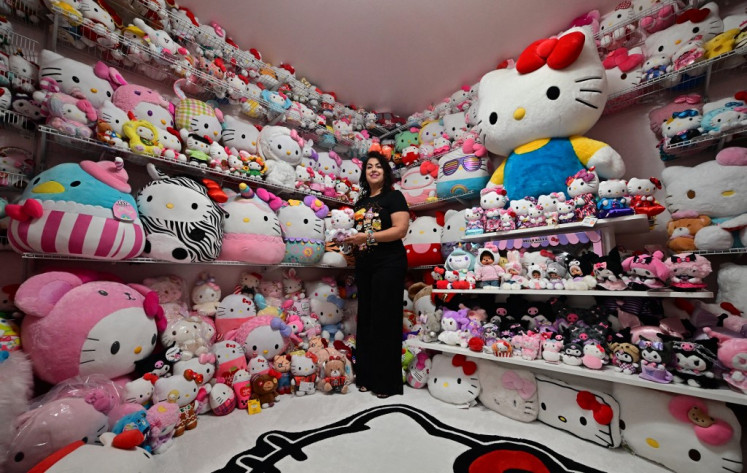 In this picture taken on October 19, 2024, Helen, founder of the 'Hello Kitty SoCal Babes' fan club, poses with her collection inside her “she-shed“ in Riverside County, California, US. Hello Kitty marks its 50th anniversary on November 1, adorning everything from handbags to rice cookers and raking in billions of dollars for her Japanese creators Sanrio. 