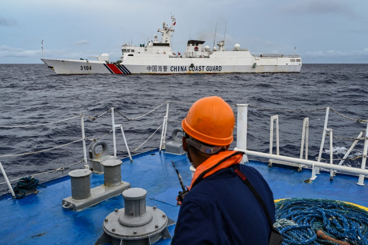 A China Coast Guard ship is seen from the Philippine Coast Guard vessel BRP Cabra during a supply mission to Sabina Shoal in disputed waters of the South China Sea on Aug. 26, 2024. Sailors aboard two Philippine Coast Guard vessels crashed through South China Sea waves trying to bring food and other supplies to colleagues holed up inside a remote ring of reefs, as Chinese ships shadowed them.