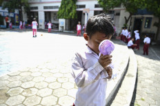 Keeping cool: A student uses a portable fan outside the classroom at an elementary school in Banda Aceh, Aceh, on May 7.