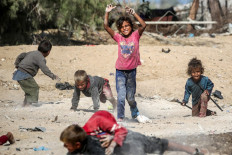 Children play together in the dust near shacks in Khan Yunis in the southern Gaza Strip on Oct. 30, 2024 amid the ongoing war in the Palestinian territory between Israel and Hamas.