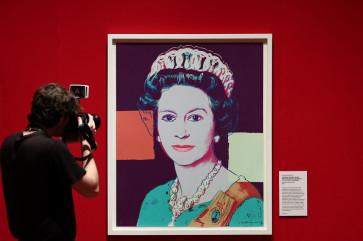 A member of the media photographs the screenprint &ldquo;Reigning Queens (Royal Edition) Queen Elizabeth II of the United Kingdom&ldquo; by American artist Andy Warhol during a press preview for &ldquo;Royal Portraits: A Century of Photography&ldquo; ahead of the exhibition at Buckingham Palace in London, on May 16, 2024. The exhibition is set to run from May 17 to Oct. 6, 2024 which will display more than 150 photographic prints of members of the royal family from the 1920's to the present day.