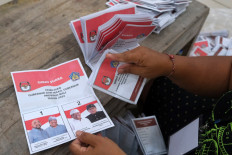 Tallying votes: A worker folds a ballot for the Bali gubernatorial election at the Tabanan Elections Commission (KPU) logistics warehouse in Bali on Oct. 30. Voting day, slated for Nov. 27, will see two candidate pairs competing: Made Muliawan Arya-Putu Agus Suradnyana and Wayan Koster-I Nyoman Giri Prasta.