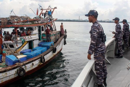 Indonesian Navy seamen prepare to search a fishing boat on Oct. 19, 2024, in the waters bordering the Malacca Strait off Lhokseumawe, Aceh, during a patrol to combat the trafficking of goods and people.