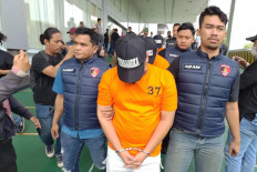 Suspicious boarding attempt: Police detectives escort three suspects of an alleged human trafficking ring at Soekarno-Hatta International Airport in Tangerang, Banten, on Nov. 5. The airport police launched an operation between Oct. 14 and Nov. 4 to nab the suspects for trying to send Indonesians abroad without proper documentation. 