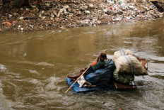 A scavenger collects garbage on Oct. 16, 2024, in the Ciliwung River in Manggarai, South Jakarta.
