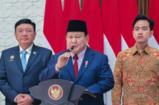 This handout picture taken and released on November 8, 2024 by the Presidential Palace shows President Prabowo Subianto (center) speaking to the press next to Vice President Gibran Rakabuming Raka (right) and the Coordinating Minister for Political and Security Affairs Budi Gunawan (left) at Halim Perdanakusuma Air Base in Jakarta. 
