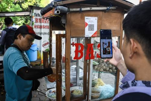 Quick, easy, patriotic: A customer scans a QRIS code on Oct. 17, 2024, to pay for a bowl of bakso (meatball soup) in Tangerang, Banten.