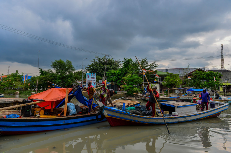Fishermen prepare to moor their boats to a wooden dock in Karangantu fishing village on Monday in Serang, Banten, as dark cloud hangs over the area. The Meteorology, Climatology and Geophysics Agency (BMKG) has called on people working in the maritime and aviation sectors to stay vigilant against potential high rainfalls caused by extreme weather in several areas across Indonesia. 